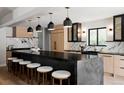 Modern kitchen featuring a large island, sleek countertops, modern appliances, and stylish pendant lighting at 5516 S Havana Ct, Englewood, CO 80111