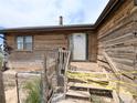 Welcoming entrance to the home with a traditional wooden porch and exterior details at 11897 Roxburg St, Strasburg, CO 80136