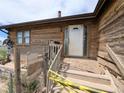 Close-up of the home's entrance, featuring a wooden porch and traditional door at 11897 Roxburg St, Strasburg, CO 80136