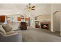 Spacious living room featuring a fireplace, ceiling fan and an open floorplan flowing into the kitchen at 20500 E Hamilton Ave, Aurora, CO 80013