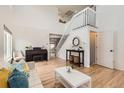 Bright living room featuring hardwood floors, a staircase, and an open layout perfect for entertaining and relaxing at 9879 Sydney Ln, Highlands Ranch, CO 80130
