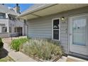 Close up of townhouse exterior with well kept garden and entry door at 17034 E Tennessee Dr # 106, Aurora, CO 80017
