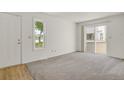 Bright living room featuring plush carpet, natural light, and a patio door at 17034 E Tennessee Dr # 106, Aurora, CO 80017