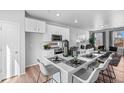 Modern kitchen with island, stainless steel appliances, and white cabinetry at 22022 E 38Th Pl, Aurora, CO 80019