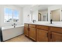 Bathroom with double sinks, soaking tub, and a large window at 39730 Congress Ln, Elizabeth, CO 80107