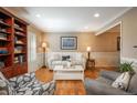 Bright living room with hardwood floors, neutral paint, wainscoting, and recessed lighting exudes relaxation at 7169 S Grape Ln, Centennial, CO 80122
