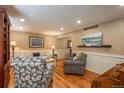 Cozy living room features hardwood floors, neutral paint, wainscoting, recessed lighting, and comfortable seating at 7169 S Grape Ln, Centennial, CO 80122