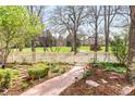 Inviting front yard with a brick pathway, lush landscaping, and a classic white picket fence at 2235 S Fillmore St, Denver, CO 80210