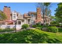 Charming townhome featuring a brick chimney and well-maintained landscaping at 2883 W Long Cir # E, Littleton, CO 80120