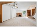 Bright living room featuring a brick fireplace, beamed ceiling, and natural light at 2883 W Long Cir # E, Littleton, CO 80120