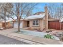 Inviting exterior of a brick home with an attached two car garage and snow dusted yard at 710 Kittredge St, Aurora, CO 80011
