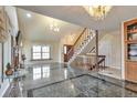 Elegant living room featuring gleaming floors, a staircase, and chandelier lighting at 710 Kittredge St, Aurora, CO 80011