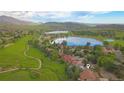 An aerial view shows neighborhood homes next to a golf course, lake, and mountain scenery at 5569 Willow Springs Dr, Morrison, CO 80465