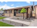 Inviting brick home with well-maintained landscaping, a covered porch, and a tidy walkway leading to the entrance at 7961 Granada Rd, Denver, CO 80221