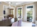 Bright dining room with a large wood table, statement chandelier, and ample natural light at 2409 S Fillmore St, Denver, CO 80210