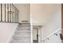 Inviting foyer with carpeted stairs, decorative railing, and neutral wall colors at 3235 S Newland St, Denver, CO 80227