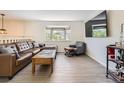 Comfortable living room featuring a large window for natural light, stylish furniture, and wood floors at 3235 S Newland St, Denver, CO 80227