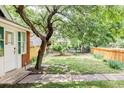Serene backyard featuring lush lawn, stone path, mature trees, and privacy fencing at 3346 W 30Th Ave, Denver, CO 80211