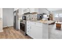 Bright kitchen with stainless steel appliances, granite countertops, and white cabinets, flowing into an adjacent living space at 2027 Terry St # 1, Longmont, CO 80501