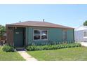 Charming single-story home features a well-maintained lawn and beautiful flower beds along the front of the house at 1730 W 51St Ave, Denver, CO 80221
