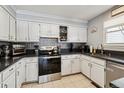 Bright kitchen features white cabinetry, updated appliances and tile backsplash at 10474 W Purgatoire Peak, Littleton, CO 80127