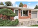 Inviting front entrance with brick facade, manicured landscaping, and a visible street address at 10525 W 18Th Ave, Lakewood, CO 80215