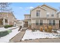 Inviting two-story townhome with covered front porch and snowy landscape at 9758 Laredo St # 30E, Commerce City, CO 80022