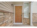 A close up of the front door with stone facade and sidelight window at 9758 Laredo St # 30E, Commerce City, CO 80022