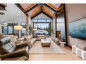 Bright living room with stone fireplace, hardwood floors, and sliding glass doors to outside view at 444 Glen Eagle Loop, Breckenridge, CO 80424