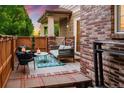 Inviting outdoor patio featuring comfortable seating, string lights, and a well-maintained brick surround at 1047 Uinta Way, Denver, CO 80230