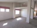 Bright and airy living area featuring plush carpet, large windows, and modern architectural support beams at 21444 E Lehigh Ave, Aurora, CO 80013