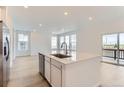 Open kitchen with stainless steel appliances and island and sliding glass door at 587 Nightsky St, Erie, CO 80516