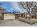 A well-kept exterior of a home featuring a two-car garage, brick accents, and a spacious driveway at 710 S Grand Ave, Fort Lupton, CO 80621