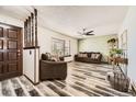 Inviting living room featuring stylish flooring, a bay window, and a ceiling fan for added comfort at 710 S Grand Ave, Fort Lupton, CO 80621