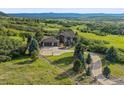 Aerial view of an estate home with a circular driveway and attached three-car garage in a rural setting at 580 Summer Mist Cir, Castle Rock, CO 80104