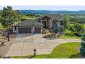 Home featuring a wide driveway, three-car garage, stone accents, and well-maintained landscaping at 580 Summer Mist Cir, Castle Rock, CO 80104