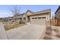 Home featuring neutral siding, stone accents, a two-car garage, and professional landscaping at 12677 Fisher Dr, Englewood, CO 80112