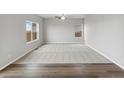 Spacious living room with neutral carpet, large windows, and modern ceiling fan at 2125 Alyssa St, Fort Lupton, CO 80621