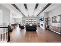 Spacious living room featuring wood beam ceiling, cozy fireplace, and seamless flow to dining and kitchen areas at 6066 Leilani Dr, Castle Rock, CO 80108