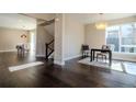 Dining area with contemporary chandelier and dark wood floors with views into other living spaces at 1270 Olive St, Denver, CO 80220