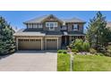 Charming two-story home featuring a three-car garage, stone accents, and a well-manicured front yard at 26764 E Canyon Ave, Aurora, CO 80016