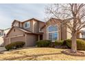 Traditional two-story home boasting a large window, mature landscaping, and a two-car garage at 4094 S Lisbon Way, Aurora, CO 80013