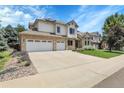 A charming two-story home features a brick and siding exterior, well-maintained lawn, and a three-car garage at 11411 W Cooper Dr, Littleton, CO 80127