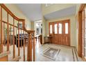 Inviting foyer showcasing a beautiful wood front door, tile flooring, and staircase leading to upper level at 11411 W Cooper Dr, Littleton, CO 80127