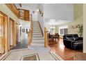 Grand foyer with high ceilings, staircase, wood floors, and elegant tile entryway into the living and dining spaces at 11411 W Cooper Dr, Littleton, CO 80127