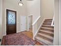 Inviting foyer featuring a decorative glass front door, hardwood floors, a staircase, and neutral wall paint at 4415 Echo Ct, Larkspur, CO 80118