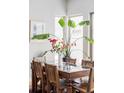 Bright dining room with glass table and chairs, large windows and vibrant plants at 7080 W Custer Ave, Lakewood, CO 80226