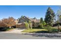 Beautiful home featuring lush greenery, mature trees, and a well-maintained front yard at 2317 Wynterbrook Dr, Highlands Ranch, CO 80126