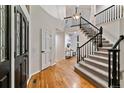 Spacious foyer with hardwood floors, elegant staircase, and modern lighting fixtures at 2317 Wynterbrook Dr, Highlands Ranch, CO 80126