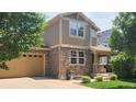 Two-story home with stone accents, an attached garage, covered porch, and well-maintained landscaping at 14232 Piney River Rd, Broomfield, CO 80023